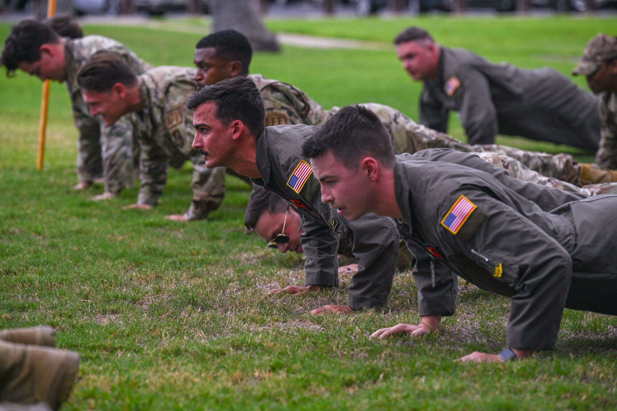 Members from the 15th Operations Group participate in memorial push-ups in honor of the lives lost during the attacks on 9/11 at Joint Base Pearl Harbor-Hickam, Hawaii, Sept. 11, 2023. Participants collectively completed 3,000 push-ups, 2996 for the victims of the attacks, one push-up for the first responders, one for the families, one for those that fell in the Global War on Terrorism, and one for the United States. (U.S. Air Force photo by Senior Airman Makensie Cooper)