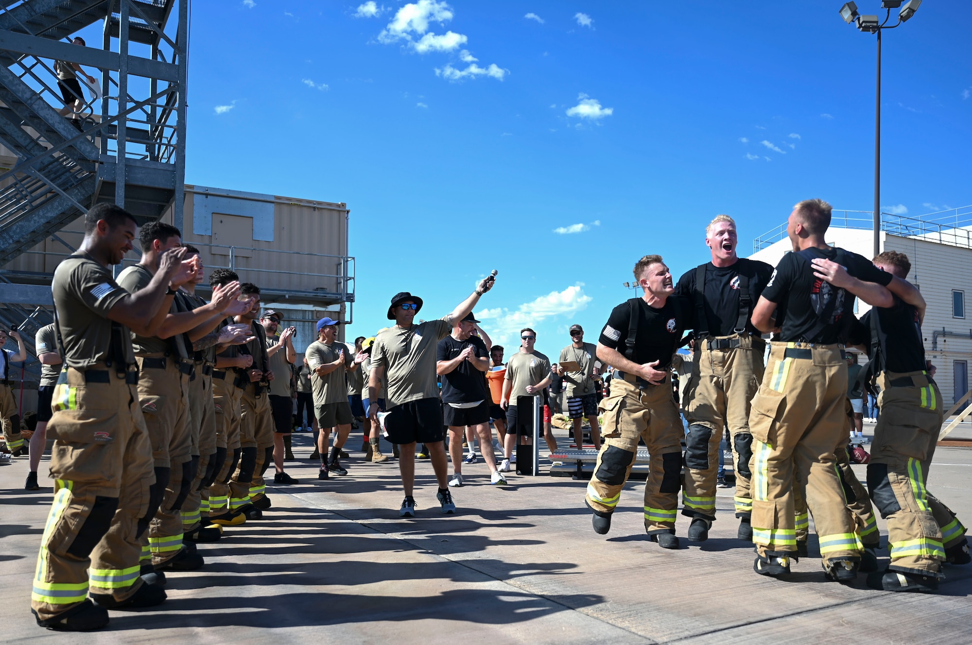 Members of the U.S. Air Force Wolf Pups team (right) celebrate their victory over the U.S. Army War Hammers team (left) after the final round of the combat challenge during the 11th Annual Blood, Sweat and Stairs event at the Louis F. Garland Department of Defense Fire Academy, Goodfellow Air Force Base, Texas, Sept. 9, 2023. Students and instructors faced off in timed endurance and strength challenges through multiple rounds competing as teams of five throughout the day; these challenges simulated different abilities firefighters must have when participating in rescue operations such as the 9/11 terrorist attacks. (U.S. Air Force photo by Airman 1st Class Madison Collier)