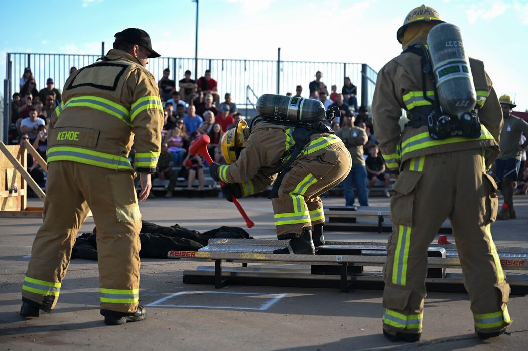 U.S. Air Force Airman 1st Class Ryan Calvo, 312th Training Squadron student, is cheered on by Master Sgt. Andrew Kehoe, 312th TRS instructor, and Airman Basic Rudy Avila, 312th TRS student, while participating in the combat challenge during the Blood, Sweat and Stairs event at the Louis F. Garland Department of Defense Fire Academy, Goodfellow Air Force Base, Texas, Sept. 9, 2023. The Keiser sled represented first responders using tools to break down doors and through rubble during 9/11. (U.S. Air Force photo by Airman 1st Class Madison Collier)