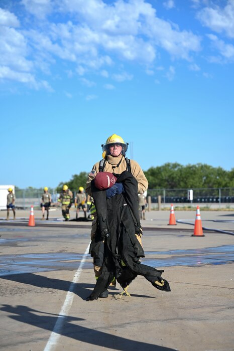 A 312th Training Squadron student drags a rescue training mannequin during the Blood, Sweat and Stairs event at the Louis F. Garland Department of Defense Fire Academy, Goodfellow Air Force Base, Texas, Sept. 9, 2023. Teams of five, made up of students and instructors, competed in a timed obstacle course that consisted of carrying a fire hose up a five-story tower, hoisting tools up a tower using a rope, hitting a 158-pound Keiser sled with a nine-pound sledgehammer, aiming an active fire hose at a target, and hauling a mannequin across the obstacle course. (U.S. Air Force photo by Airman 1st Class Madison Collier)