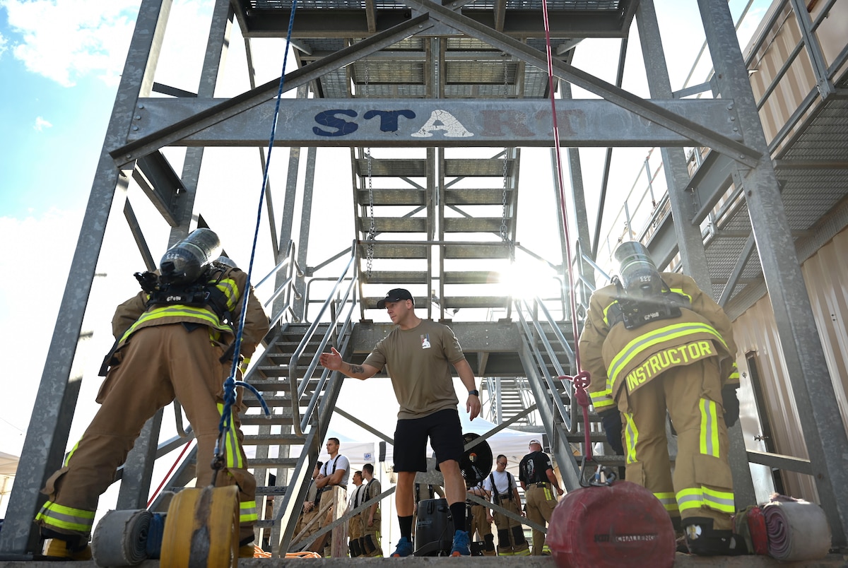 Members assigned to the 312th Training Squadron prepare to begin the first obstacle of the combat challenge during the 11th Annual Blood, Sweat and Stairs event at the Louis F. Garland Department of Defense Fire Academy, Goodfellow Air Force Base, Texas, Sept. 9, 2023. Participants climbed up a five-story tower while holding a hose. This obstacle simulated what first responders had to endure while carrying their equipment into the tower to extract survivors during 9/11. (U.S. Air Force photo by Airman 1st Class Madison Collier)