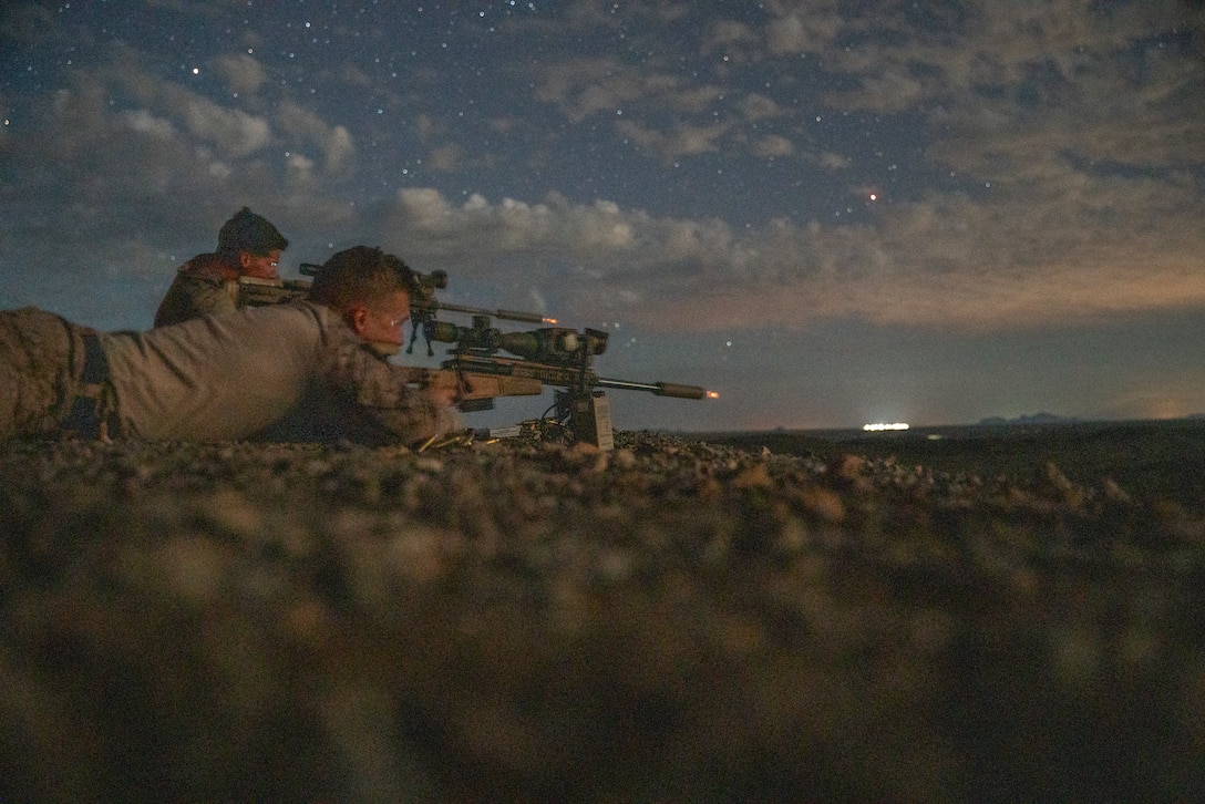 U.S. Marines assigned to Reconnaissance Company, 15th Marine Expeditionary Unit, engage targets with sniper rifles in low-light conditions during Realistic Urban Training exercise at Yuma Proving Grounds, Arizona, Aug. 21, 2023. RUT is a land-based, pre-deployment exercise that enhances the integration and collective capability of the Marine Air-Ground Task Force while providing the 15th MEU with an opportunity to train and execute operations in an urban environment. (U.S. Marine Corps photo by Sgt. Patrick Katz)