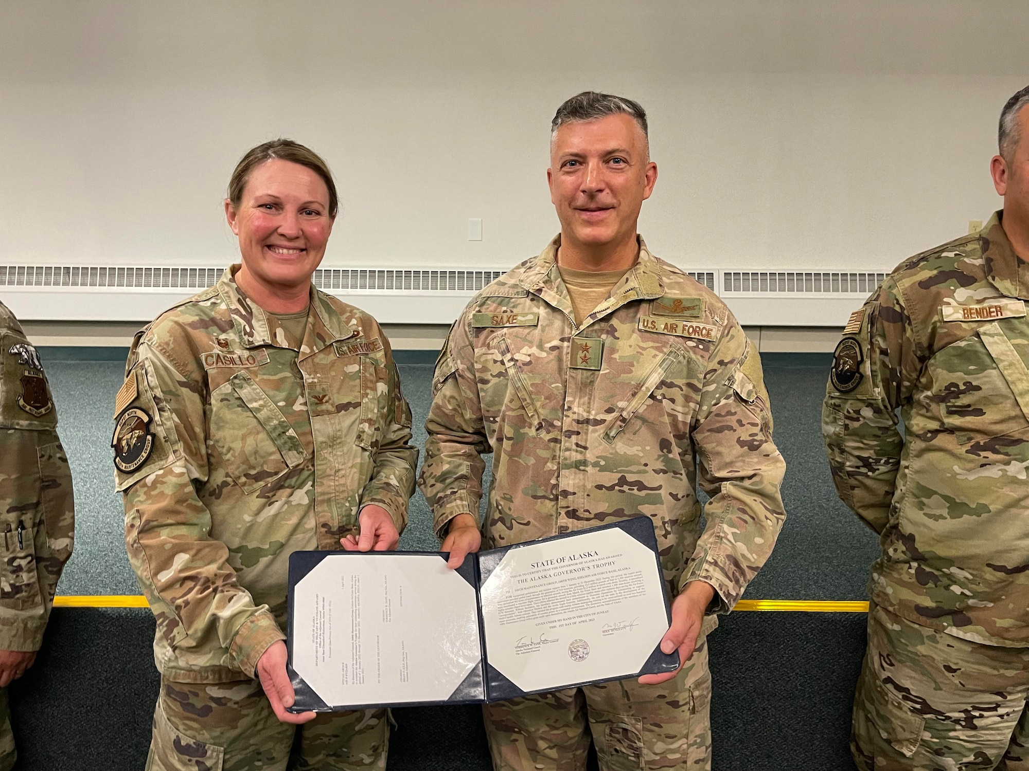 Col. Jennifer Casillo, 168th Maintenance Group commander, stands alongside Maj. Gen. Torrence Saxe, the adjutant General of the Alaska National Guard, as she receives the Alaska Governor's Trophy