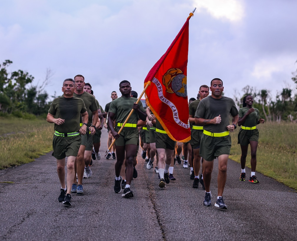 Marines with Marine Corps Base (MCB) Camp Blaz sing cadences during a motivational run on MCB Camp Blaz, Guam, August 10, 2023. The Marines prepared for a motivational run to lift camaraderie within the unit. The tradition of motivational runs represents the core values of the Marine Corps, to show unit pride and build esprit de corps. (U.S. Marine Corps photo by Lance Cpl. Garrett Gillespie)