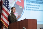 Woman stands behind a microphone at a podium speaking