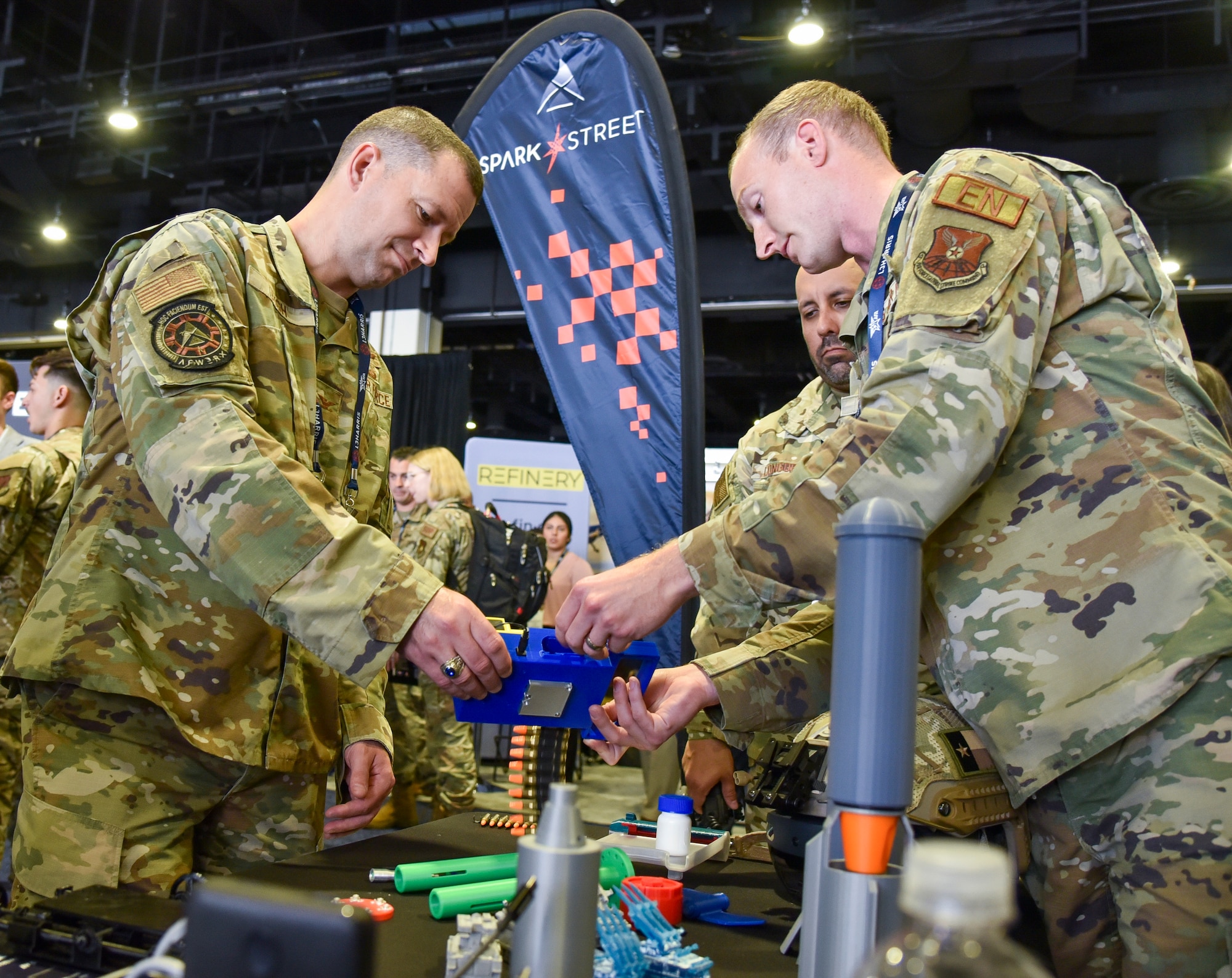 Capt. Blake Gillund, AFWERX Spark Street booth exhibiitor, briefs Col. Elliott Leigh, AFWERX director and the Chief Commercialization Officer for the Department of the Air Force, at the Air, Space and Cyber Conference at the Gaylord National Resort and Convention Center in National Harbor, Maryland, Sept. 11, 2023. Spark, an AFWERX division, connects Airmen and Guardian operators to commercial innovators and acquisition processes. Spark Street, a custom set of four booth spaces, will showcase nearly 20 Spark Cells from around the world. (U.S. Air Force photo by Matthew Clouse)