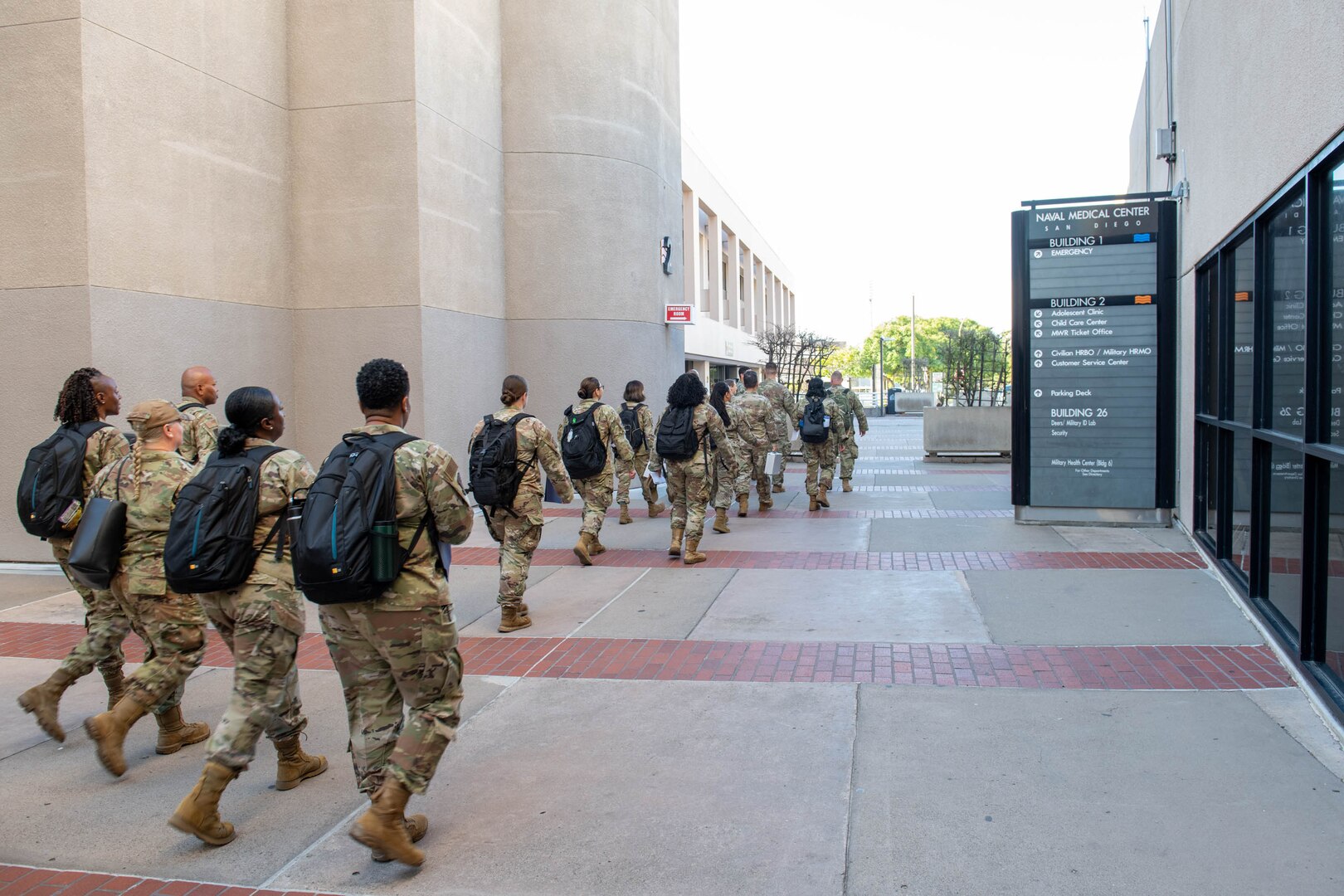 Group of Airmen walking down sidewalk.