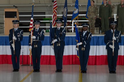Five Air Force Honor Guard members stand before stage.