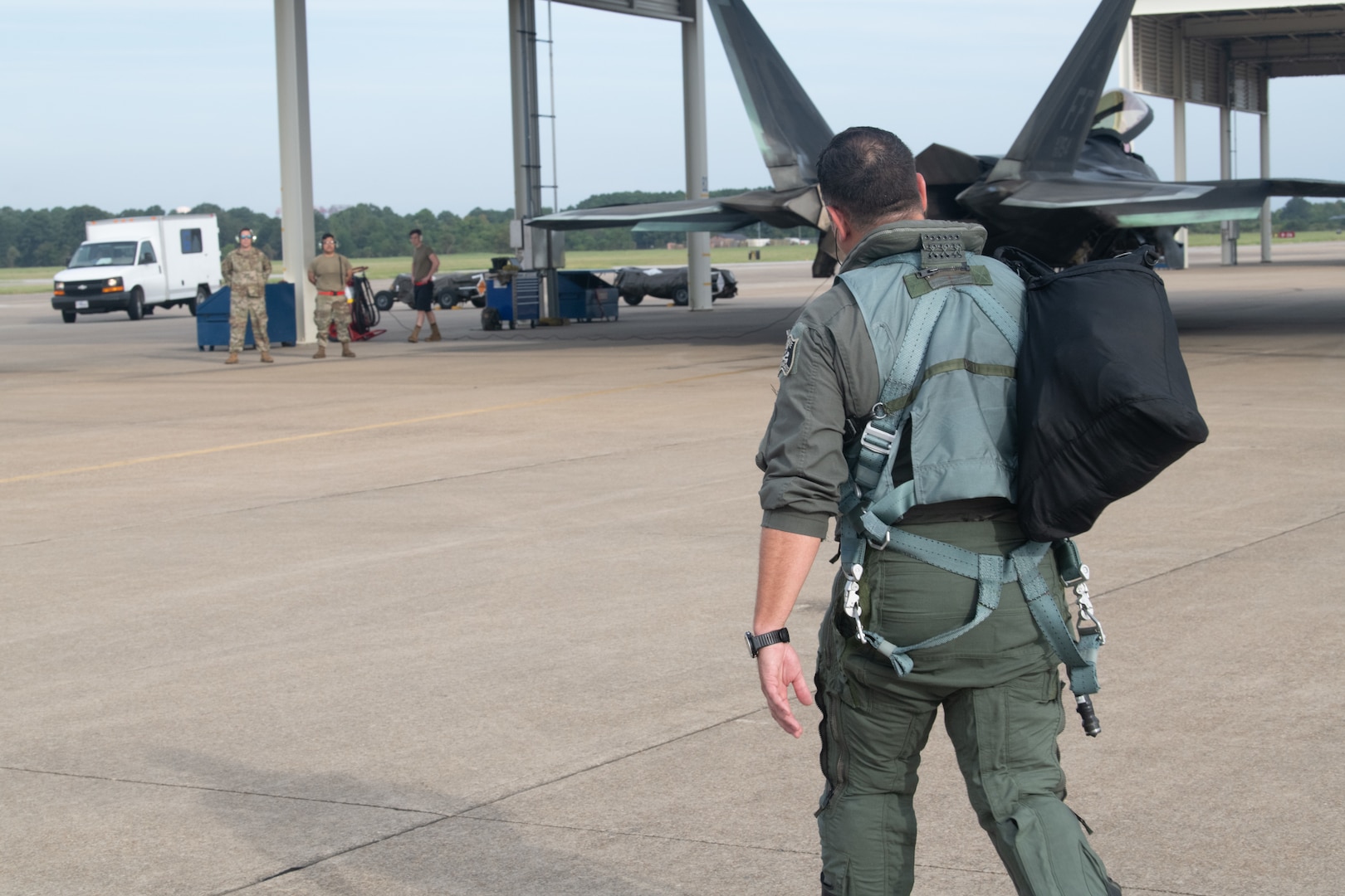 Pilot walking on flight line to F-22.