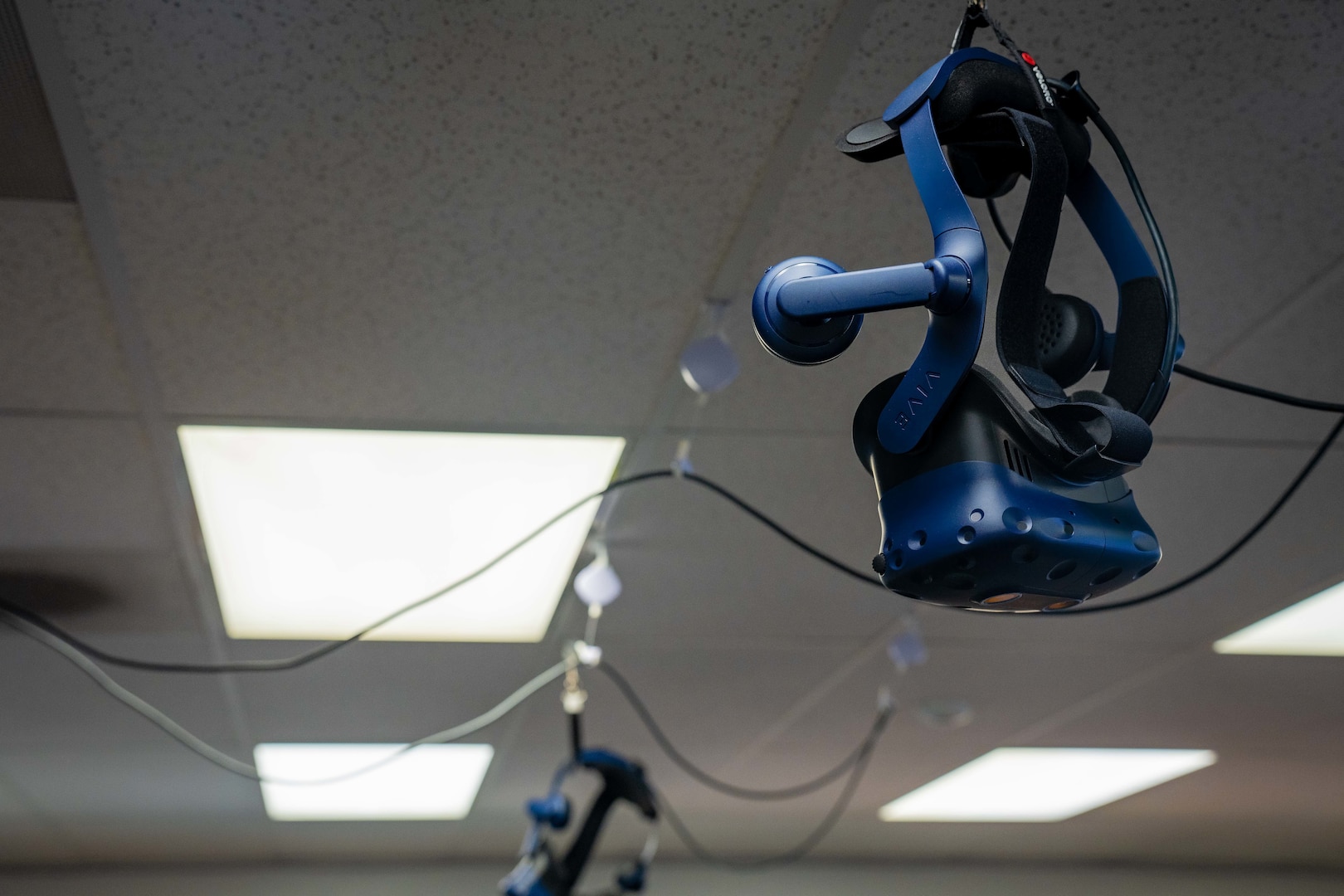 A virtual reality headset hanging from the ceiling.