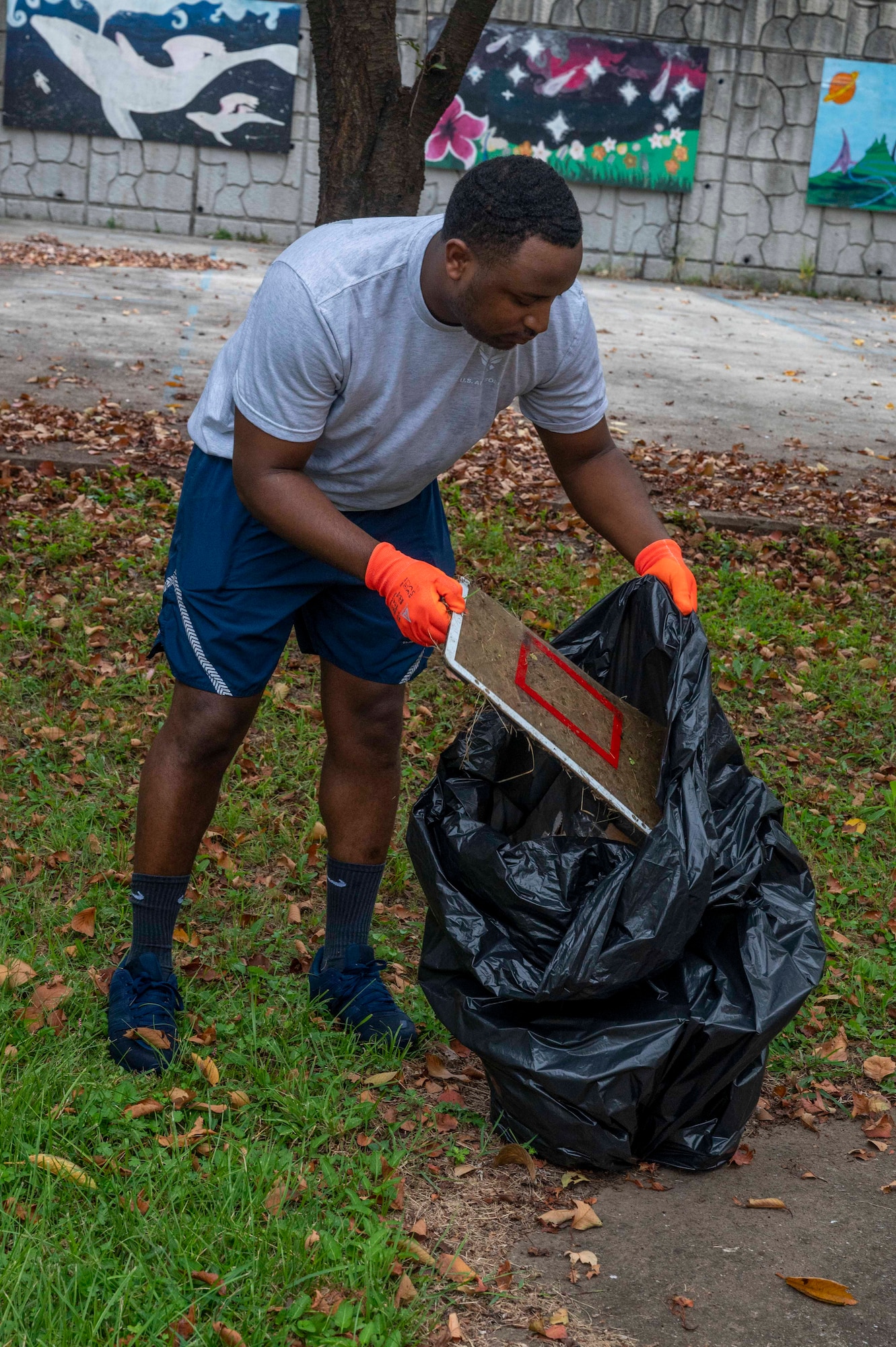 U.S. Air Force Staff Sgt. Quashon Skinner, 51st Medical Support Squadron pharmacy noncommissioned officer in charge, picks up trash during a base clean up at Osan Air Base, Republic of Korea, Sept. 13, 2023. Throughout the installation, Airmen and civilians came together to remove litter, gather recyclables and clear debris with the aim of preserving base infrastructure and maintaining environmental standards. (U.S. Air Force photo by Senior Airman Aaron Edwards)