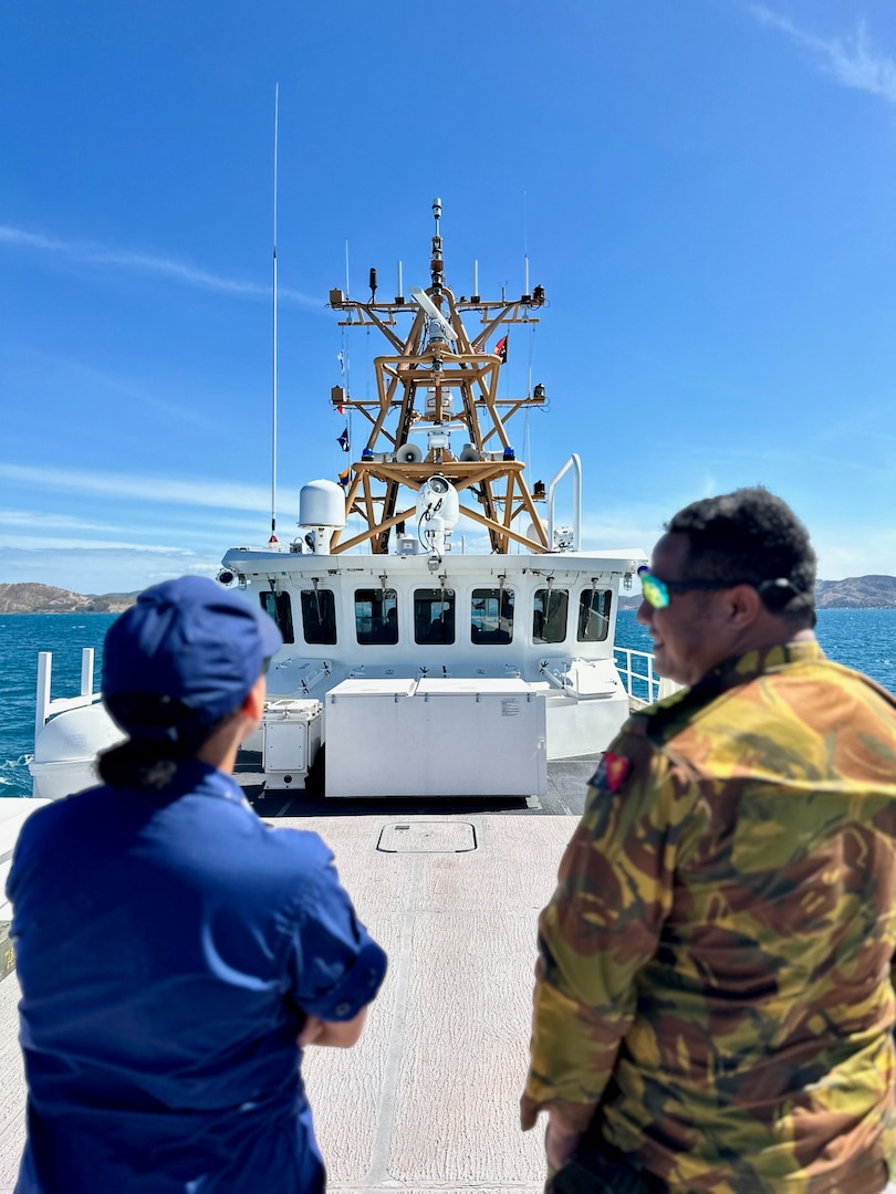 Lt. Jalle Merritt of USCGC Myrtle Hazard (WPC 1139) talks with Lt. Nathan Thavaran of the Papua New Guinea Defence Force as they depart Port Moresby for the second leg of a combined patrol on Aug. 31, 2023, in the Coral Sea off Papua New Guinea. The U.S. Coast Guard was in Papua New Guinea at the invitation of the PNG government to join their lead in maritime operations to combat illegal fishing and safeguard marine resources following the recent signing and ratification of a bilateral maritime law enforcement agreement between the United States and Papua New Guinea. (U.S. Coast Guard photo by Chief Warrant Officer Sara Muir)