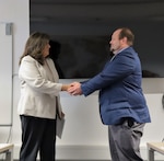 Phillip Dennis receives a director's coin from Ms Dilly