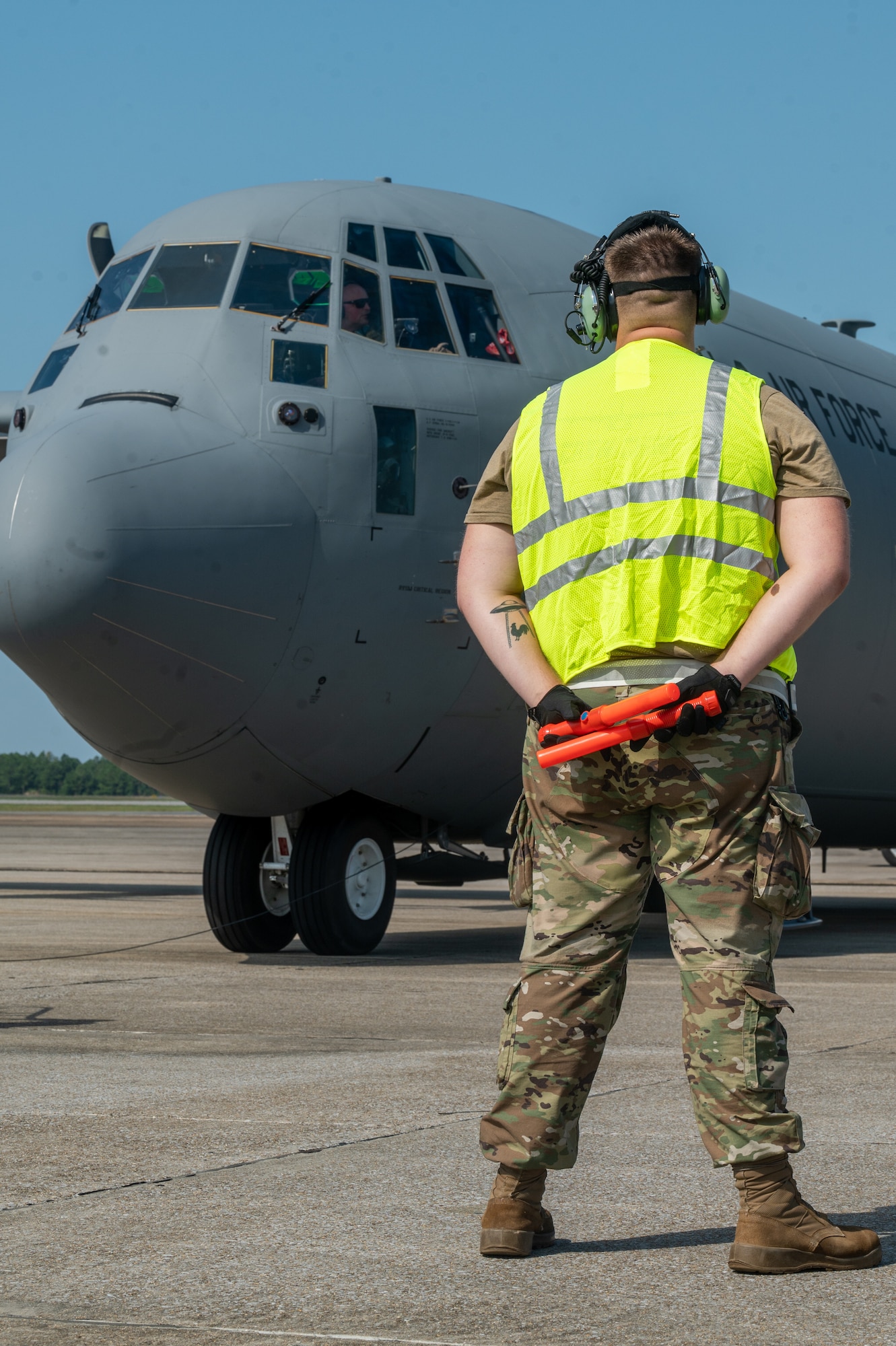 An airman assigned to the 130th Airlift Wing awaits the takeoff of a C-130J-30 during the Fly Away Readiness Exercise (FLARE-V), Sept. 8, 2023, at Gulfport Combat Readiness Training Center (CRTC), Gulfport, Miss. FLARE-V is a Commander Directed Readiness Exercise designed to inform commanders of their units’ ability to Generate- Employ-Sustain combat capability across the spectrum of warfare. (U.S. Air National Guard photo by 2nd Lt. De-Juan Haley)