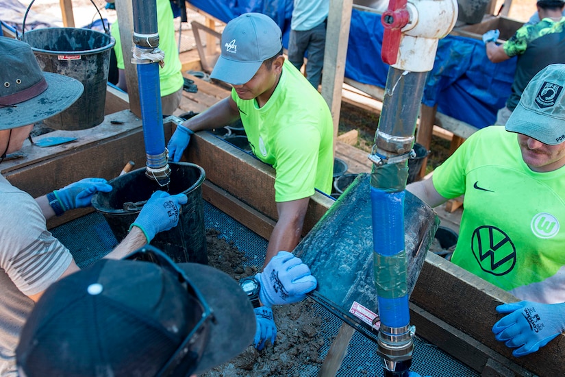 People sift dirt using water.