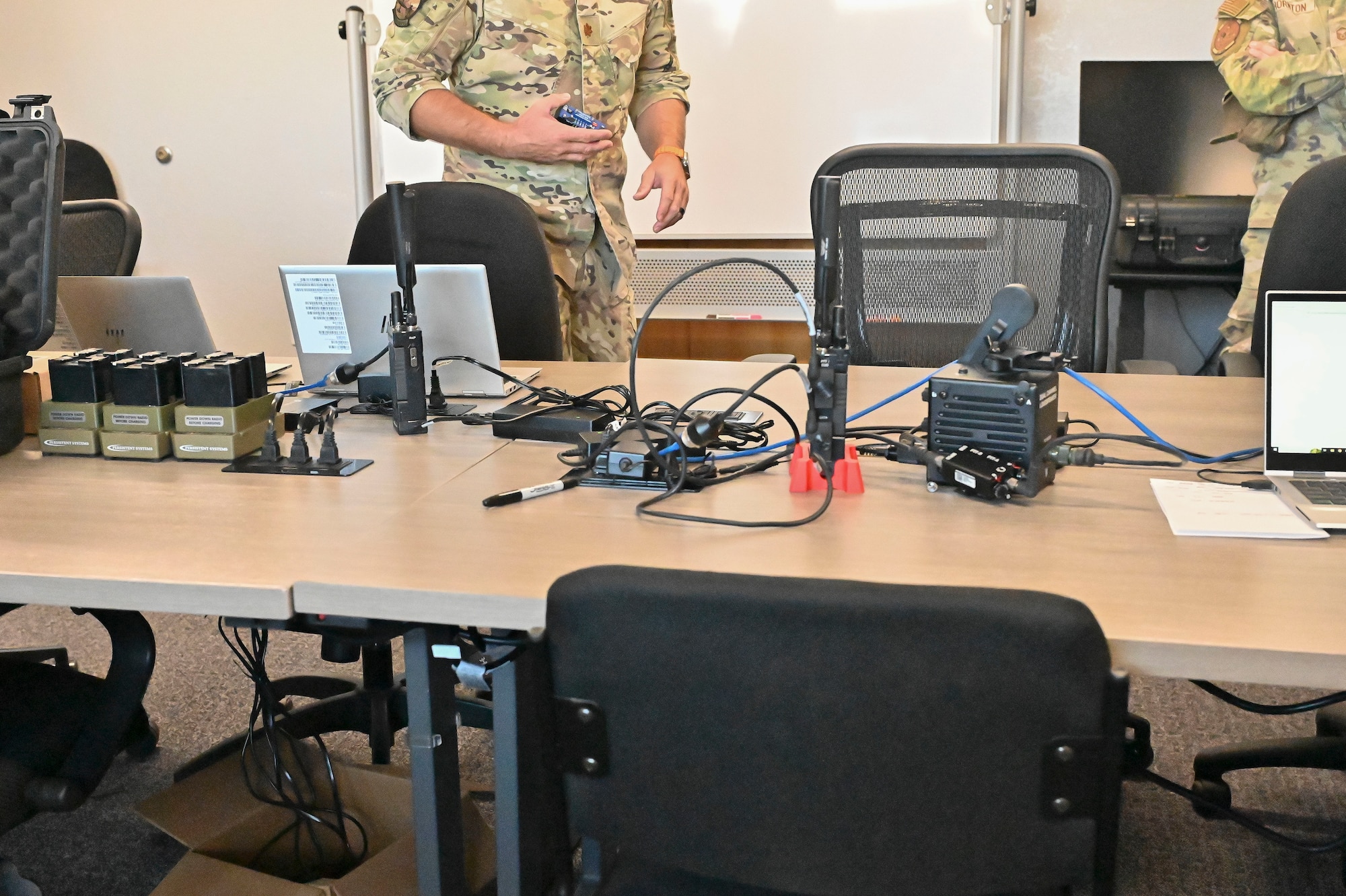 Pictured above is a table with radios stacked on it.