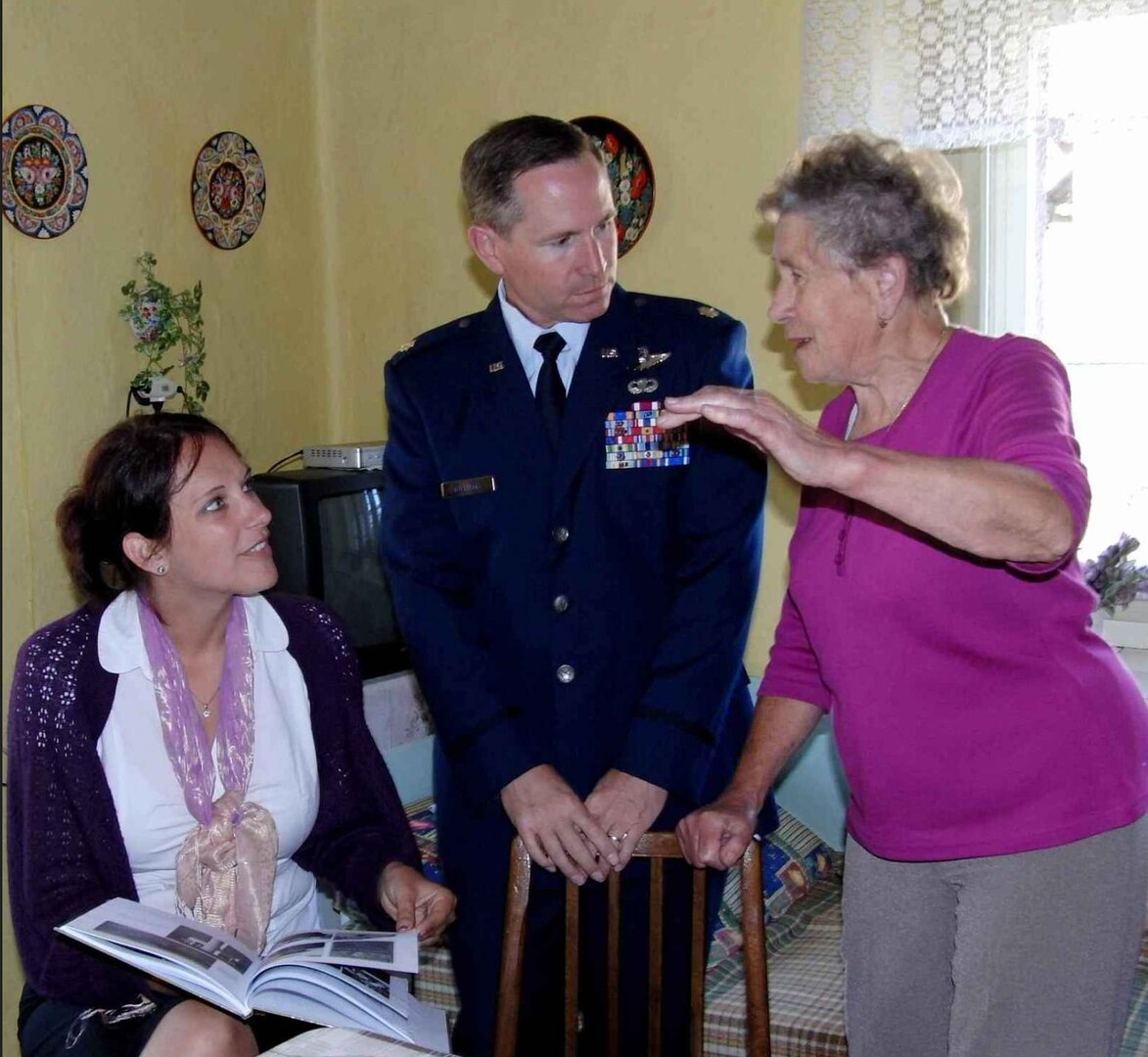 In this file photo from June 2012, Maj. John Williams looks through a book belonging to Ms. Zdenka Sladkova, an 81-year-old Czech woman who, at age 14, witnessed the sacrifice of an American pilot who crashed and was killed while strafing a German convoy near her small village.