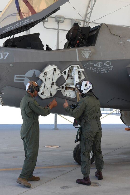 U.S. Marine Corps Lt. Col. Jesse M. Peppers, right, commanding officer, Marine Fighter Attack Squadron (VMFA) 211, communicates with his maintainer during a pre-flight check at Marine Corps Air Station Yuma, Arizona, Aug. 28, 2023. U.S. Marine Corps Brig. Gen. Robert B. Brodie, assistant wing commander, 3rd Marine Aircraft Wing, visited the air station to observe operations and training at VMFA-211 and VMFA-122. (U.S. Marine Corps photo by Lance Cpl. Elizabeth Gallagher)