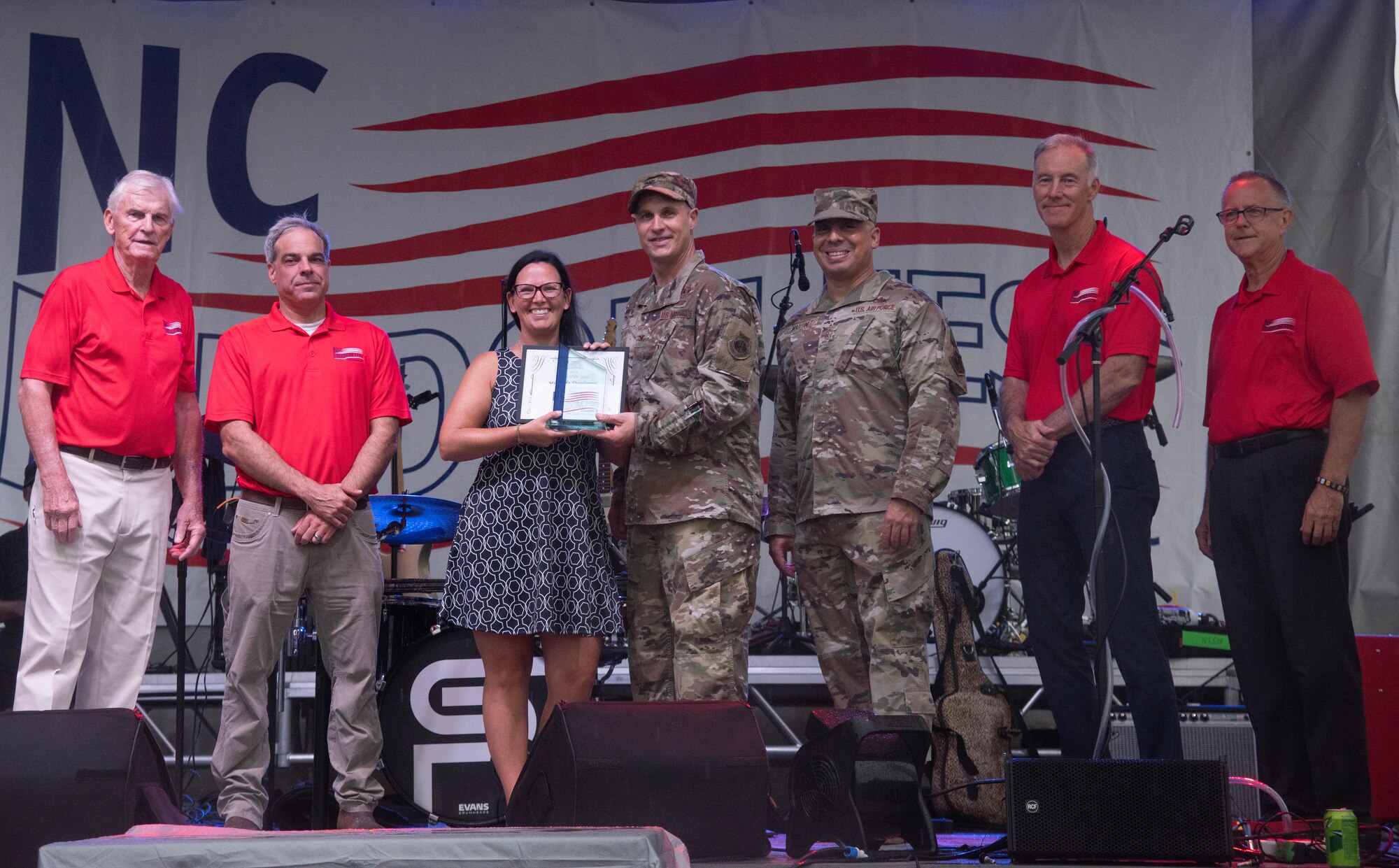 Col. Lucas Teel, center right, 4th Fighter Wing commander, and Chief Master Sgt. Martinez, second right, 4th FW command chief, recognize Kala Dunleavy, center left, 4th Equipment Maintenance Squadron key spouse mentor, for earning the Military Appreciation Award for the Airman category during NC Freedom Fest, at downtown Goldsboro, North Carolina, Sept. 9, 2023.