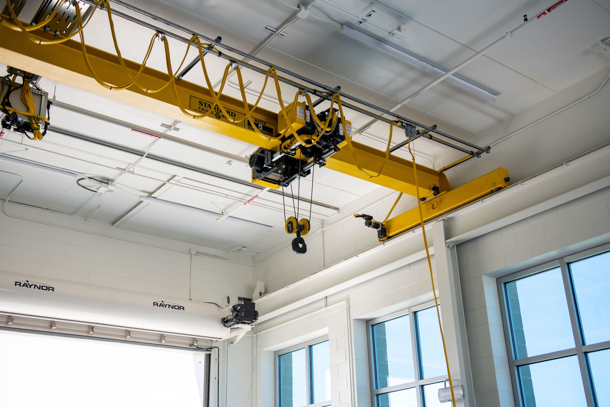 Large yellow overhead crane installed on building roof.