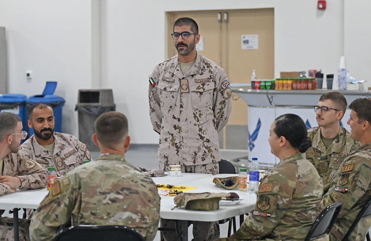 A photo of a man standing at a table.