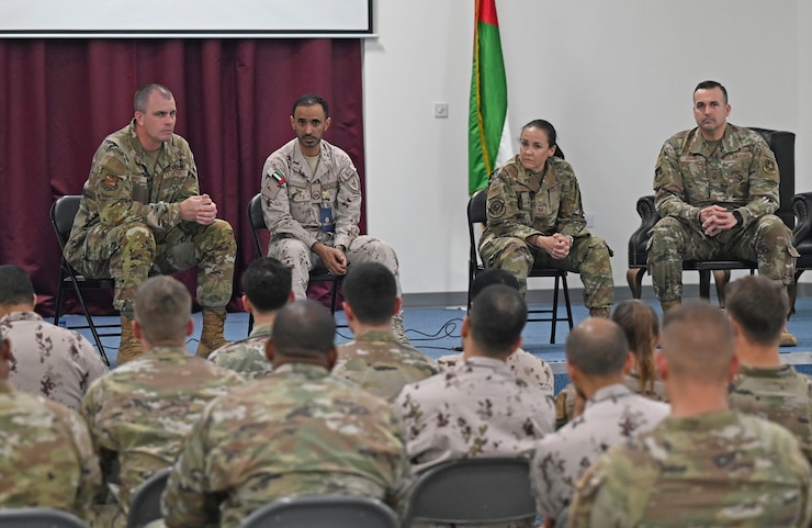 A photo of four people on a stage talking to the audience.