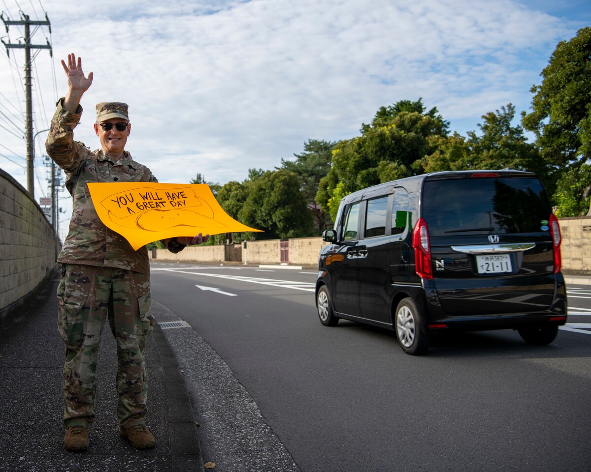 A military man holds a sign.