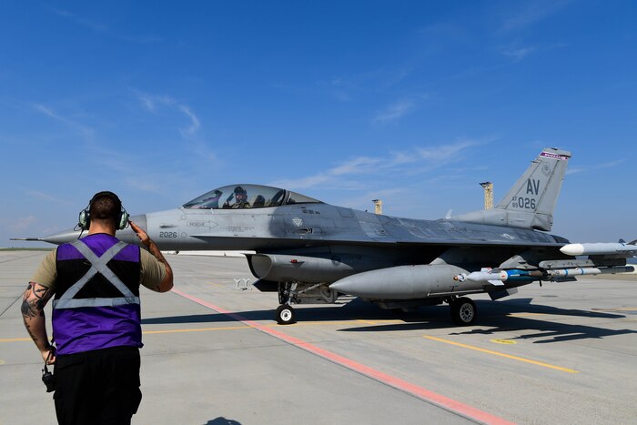 U.S. Air Force Airman from the 510th Fighter Generation Squadron marshals a jet during exercise Ample Strike.