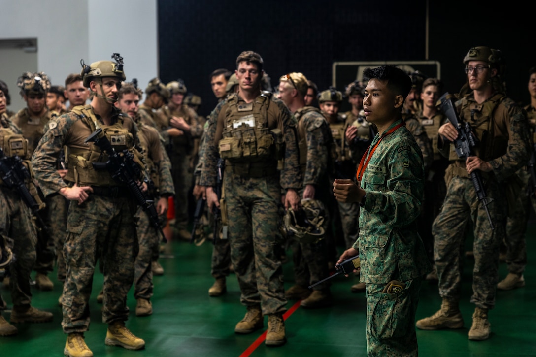 A Singapore Army soldier with 3rd Battalion Singapore Guards, 7th Singapore Infantry Brigade, gives a safety brief to U.S. Marines with Marine Rotational Force-Southeast Asia (MRF-SEA), I Marine Expeditionary Force, before a virtual live-fire scenario during Exercise Valiant Mark 2022 at the Multi-Mission Range Complex on Pasir Laba Camp, Singapore, Dec. 2, 2022. Valiant Mark is an annual, bilateral training exercise designed to enhance interoperability, build mutual defense capabilities, and strengthen military-to-military relationships between the U.S. Marine Corps and Singapore Armed Forces. MRF-SEA is an operational model developed by Marine Corps Forces Pacific that postures scalable I Marine Expeditionary Forces west of the International Date Line, conducts a series of planned subject matter experts exchanges, and advances security objectives shared with our Allies and Partners. (U.S. Marine Corps photo by Sgt. Ryan H. Pulliam)