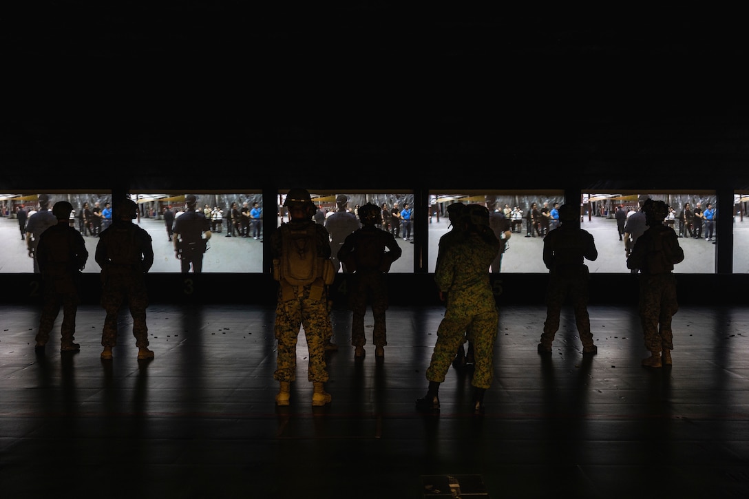 U.S. Marines with Marine Rotational Force-Southeast Asia (MRF-SEA), I Marine Expeditionary Force, wait to engage targets at virtual live-fire scenario during Exercise Valiant Mark 2022 at the Multi-Mission Range Complex on Pasir Laba Camp, Singapore, Dec. 2, 2022. Valiant Mark is an annual, bilateral training exercise designed to enhance interoperability, build mutual defense capabilities, and strengthen military-to-military relationships between the U.S. Marine Corps and Singapore Armed Forces. MRF-SEA is an operational model developed by Marine Corps Forces Pacific that postures scalable I Marine Expeditionary Forces west of the International Date Line, conducts a series of planned subject matter experts exchanges, and advances security objectives shared with our Allies and Partners. (U.S. Marine Corps photo by Sgt. Ryan H. Pulliam)