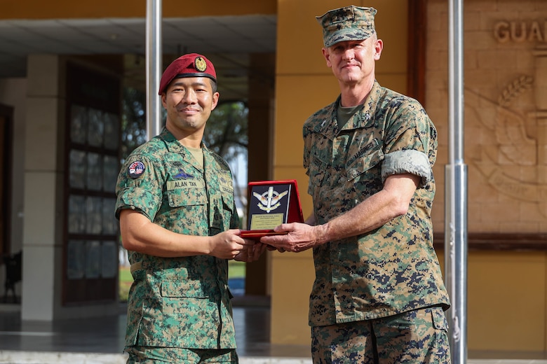 Singapore Guard Col. Tan Yukun Alan, left, commander of 7th Singapore Infantry Brigade gives U.S. Marine Corps Col. Thomas M. Siverts, commanding officer of Marine Rotational Force Southeast Asia (MRF-SEA), I Marine Expeditionary Force, a parting gift during the closing ceremony for Exercise Valiant Mark 2022 on Bedok Camp II, Singapore, Dec. 6, 2022. Valiant Mark is an annual, bilateral training exercise designed to enhance interoperability, build mutual defense capabilities, and strengthen military-to-military relationships between the U.S. Marine Corps and Singapore Armed Forces. MRF-SEA is an operational model developed by Marine Corps Forces Pacific that postures scalable I Marine Expeditionary Forces west of the International Date Line, conducts a series of planned subject matter expert exchanges, and advances security objectives shared with our Allies and Partners. (U.S. Marine Corps photo by Sgt. Jailine L. AliceaSantiago)