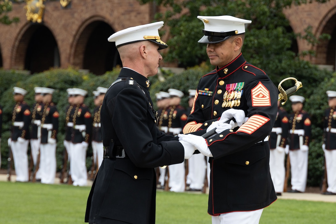 The 36th Assistant Commandant of the Marine Corps, Gen. Eric M. Smith, left, passes the sword of office to Sgt. Maj. Carlos A. Ruiz during the Sergeant Major of the Marine Corps relief and appointment ceremony at Marine Barracks Washington, Washington D.C., August 10, 2023. Sergeant Maj. Ruiz was appointed as the 20th Sergeant Major of the Marine Corps. (U.S. Marine Corps photo by Sgt. Rachaelanne Woodward)