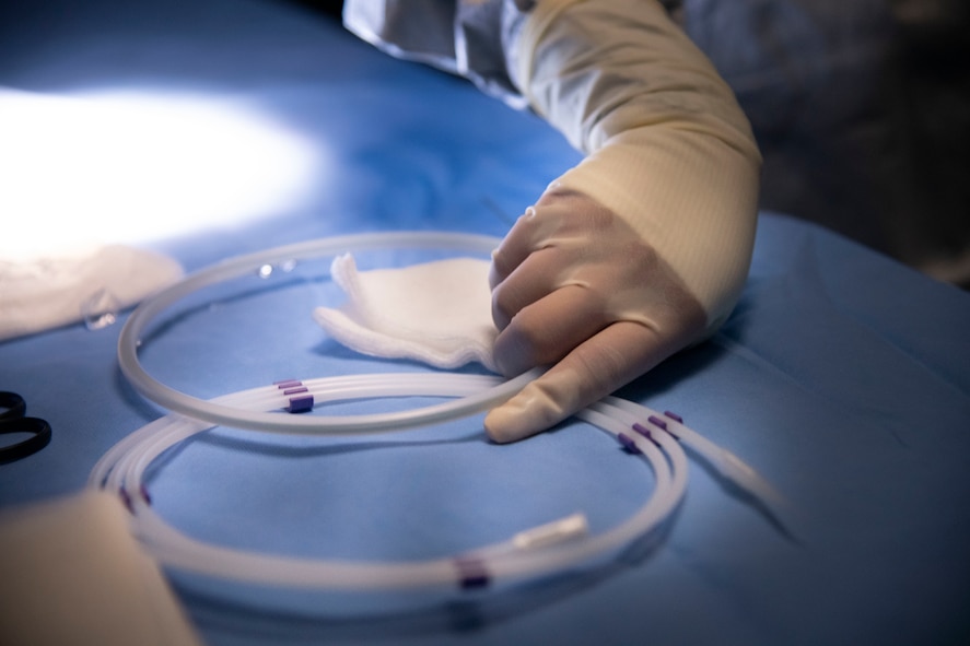 surgical technician's gloved hand prepares equipment