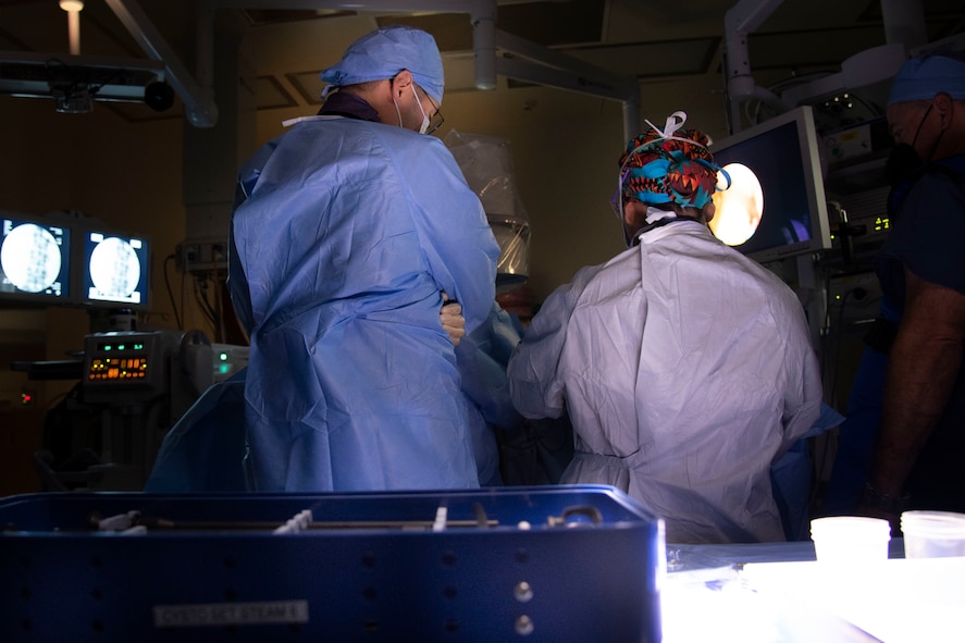 military medical professionals in gowns observe surgery