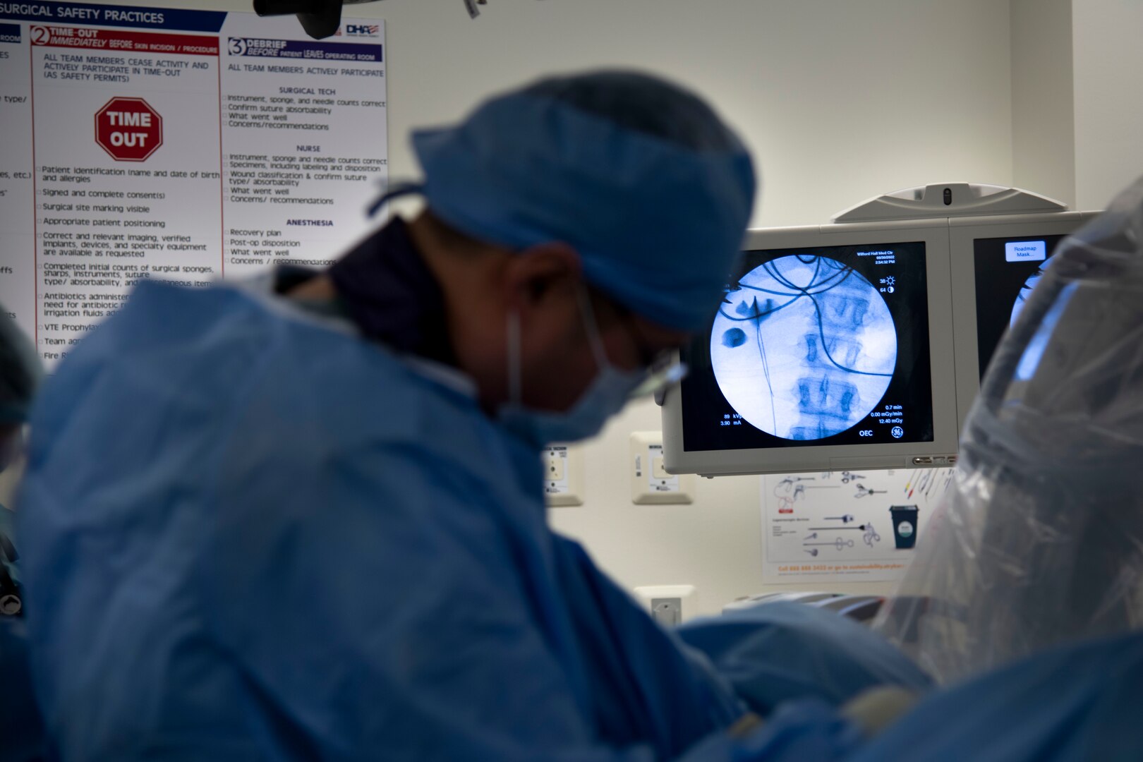 military doctor in foreground, medical monitor in background