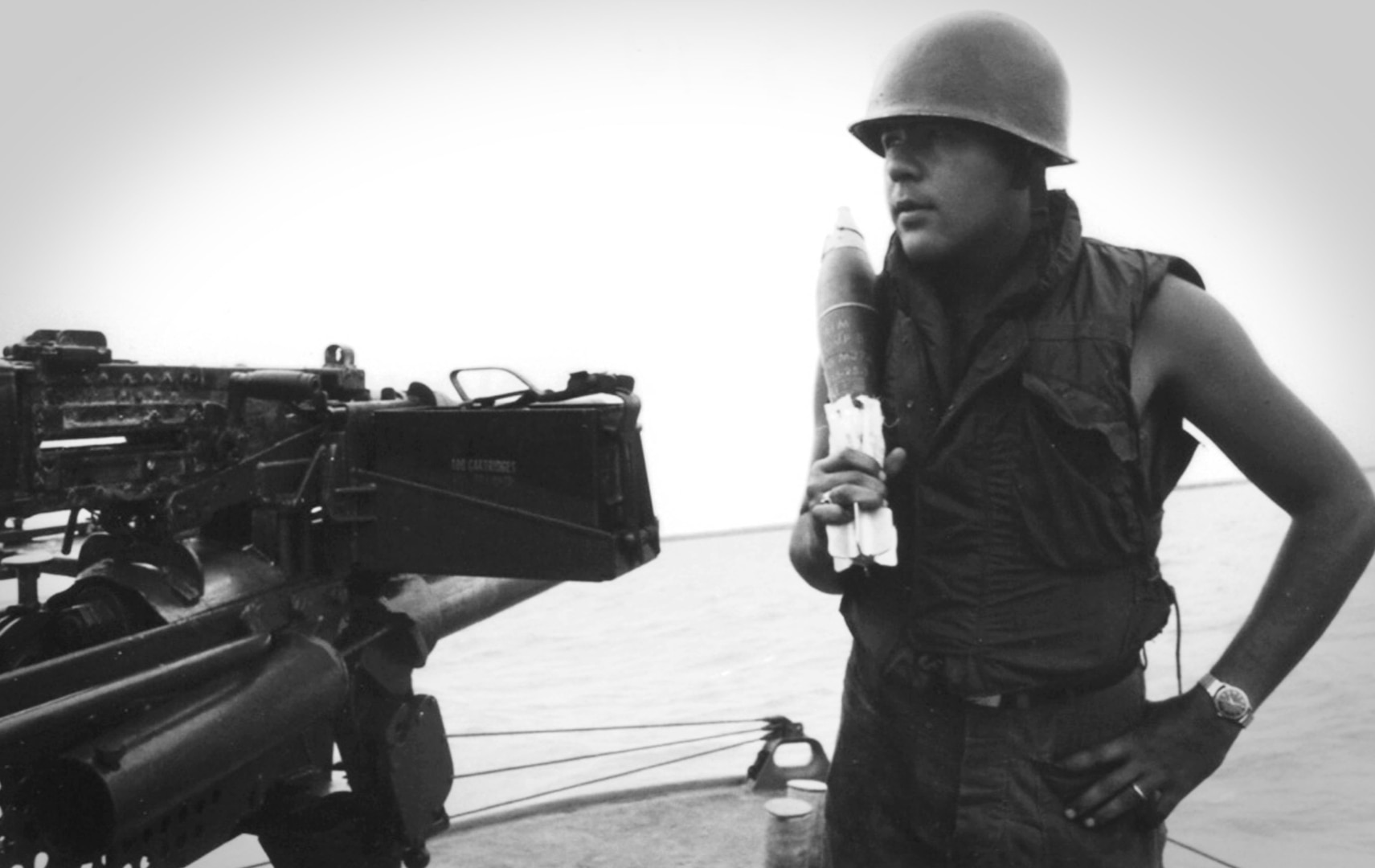 Villarreal in flak vest and combat helmet standing beside Point Banks’s deck gun. (U.S. Coast Guard)