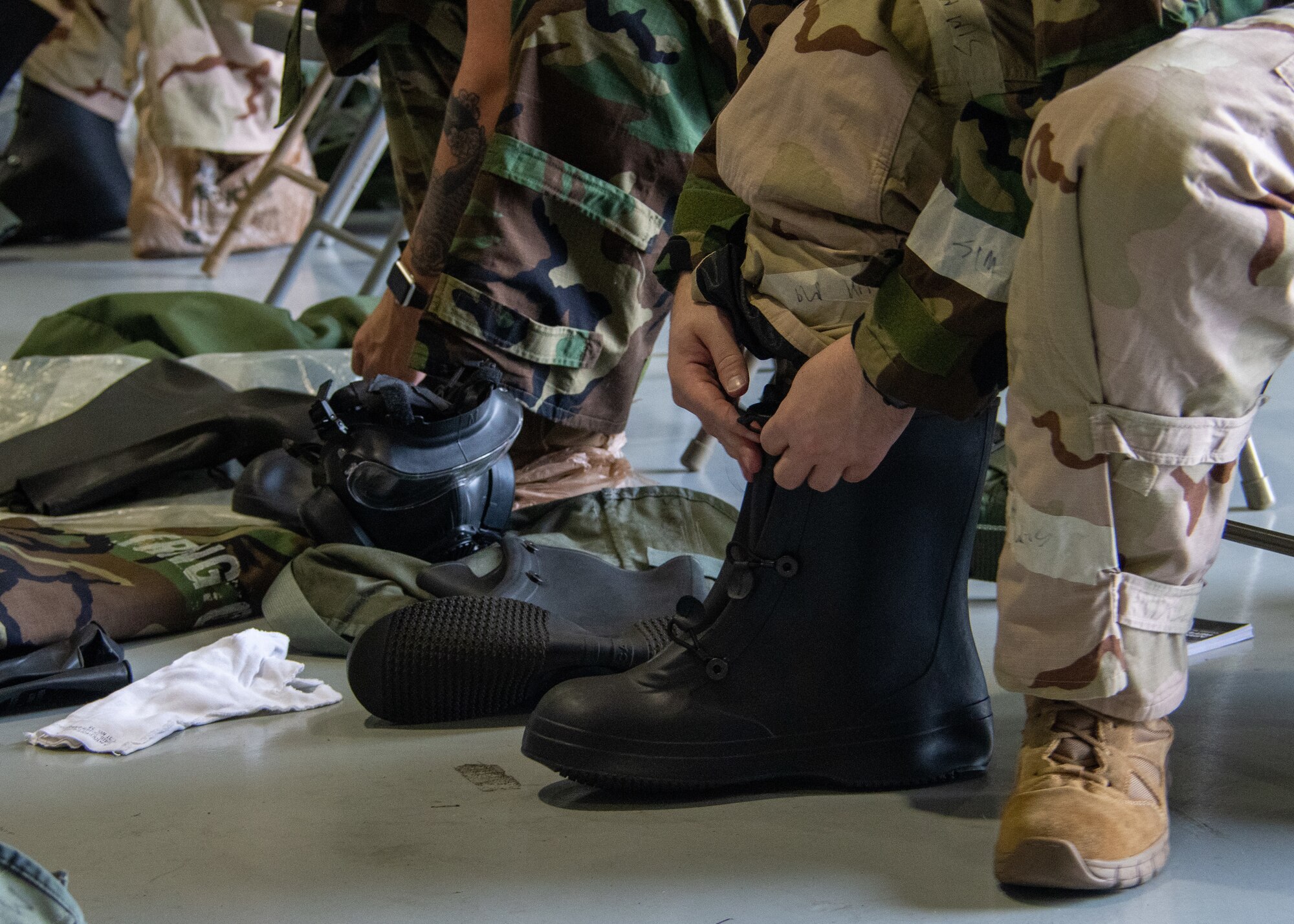 Airmen don protective boots during a CBRN Defense Training held on Sept. 12, 2023, at Dobbins Air Reserve Base, Ga. The donning of protective boots is part of MOPP level two, which also requires the user to wear field gear and an overgarment. (U.S. Air Force photo by Tech. Sgt. Joshua Kincaid)