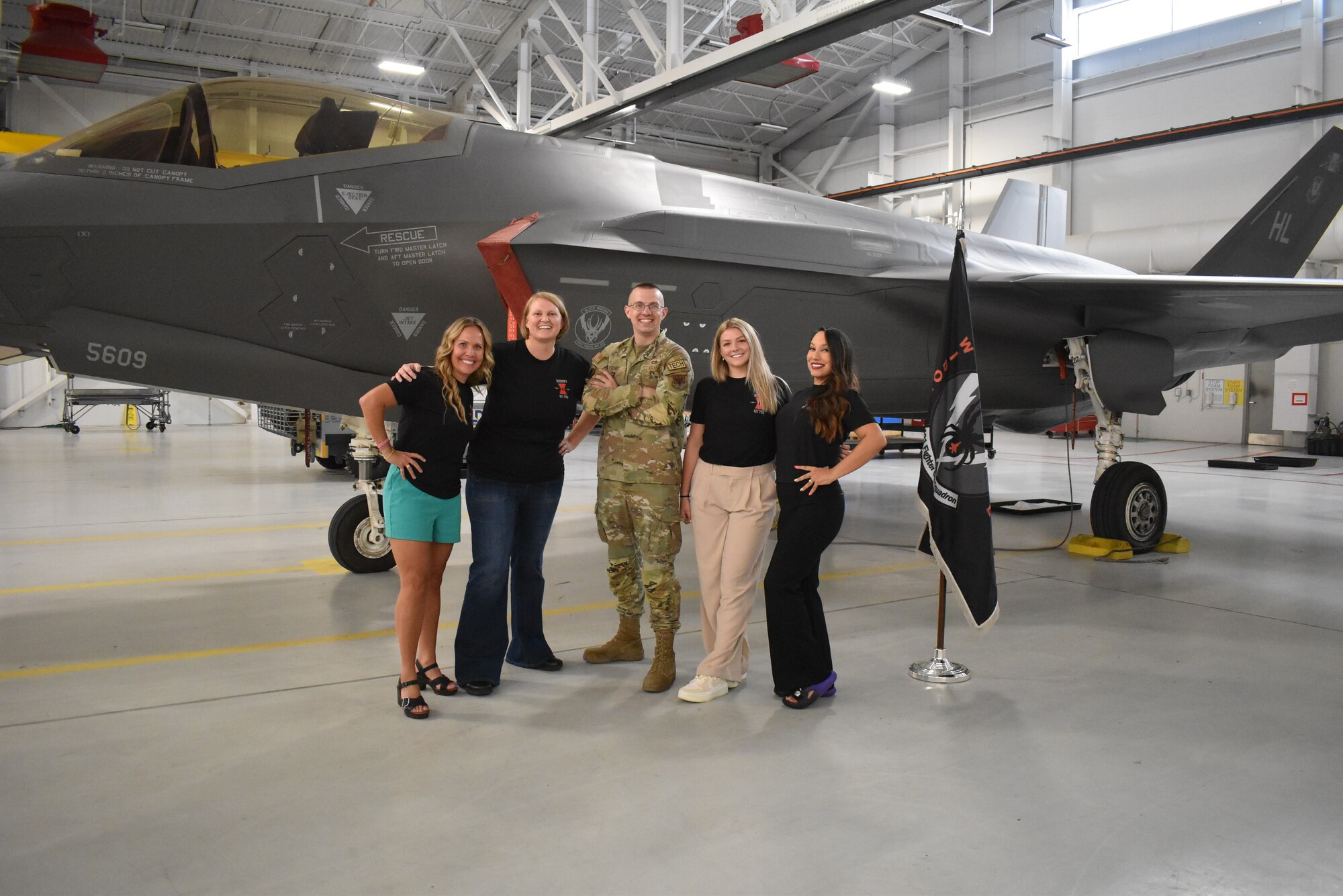 A photo of the Rosie Project coordinators in front of an F-35