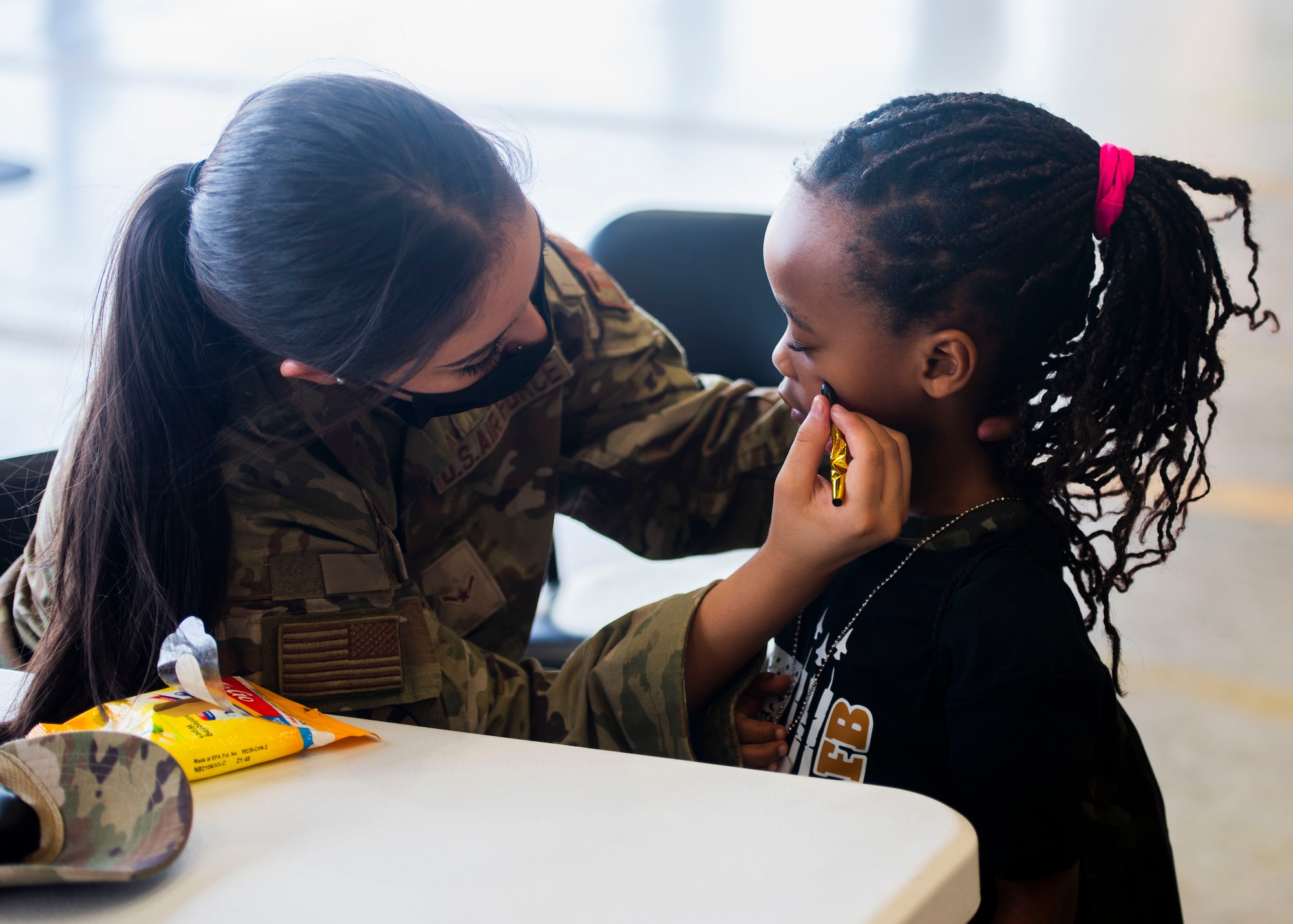 U.S. Air Force Airman Angelica Arce, 944th Logistics Support Squadron inbound specialist, applies face paint to a child at the 15th annual Operation KIDS event Sept. 9, 2023, at Luke Air Force Base, Arizona.