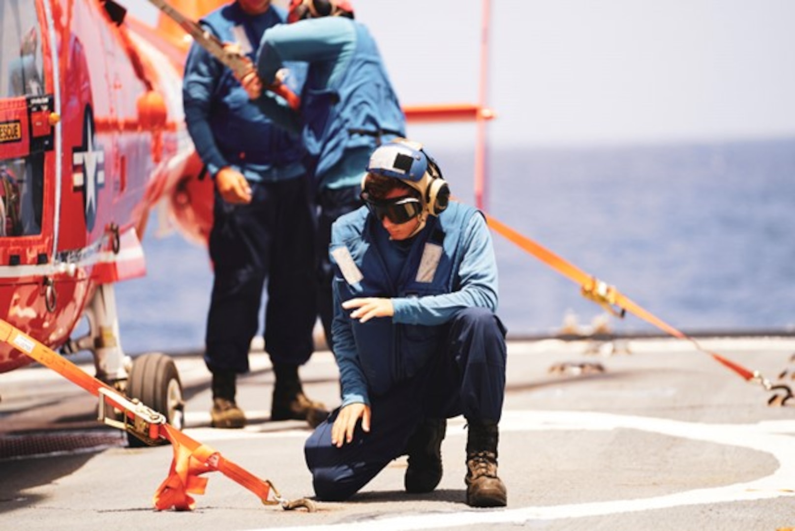 Coast Guard Seaman Cody Browning, assigned to U.S. Coast Guard Cutter Thetis (WMEC 910), secures an MH-65 helicopter from the Coast Guard Helicopter Interdiction Tactical Squadron to the cutter’s flight deck, Aug. 4, 2023, while underway in the Eastern Pacific Ocean. Thetis patrolled the Eastern Pacific Ocean and Western Caribbean Sea in support of the Coast Guard’s mission to combat illegal drug trafficking. (U.S. Coast Guard photo by Ensign Jordan Russell).
