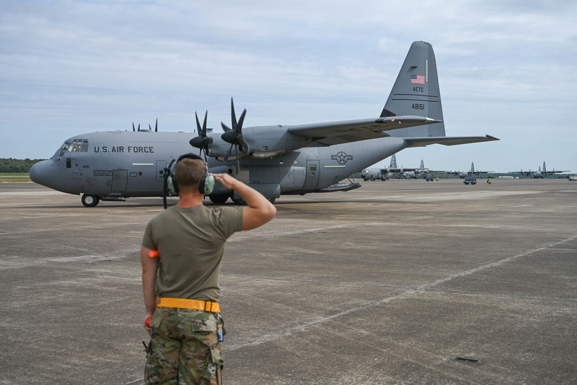 An Airman salutes an aircraft.