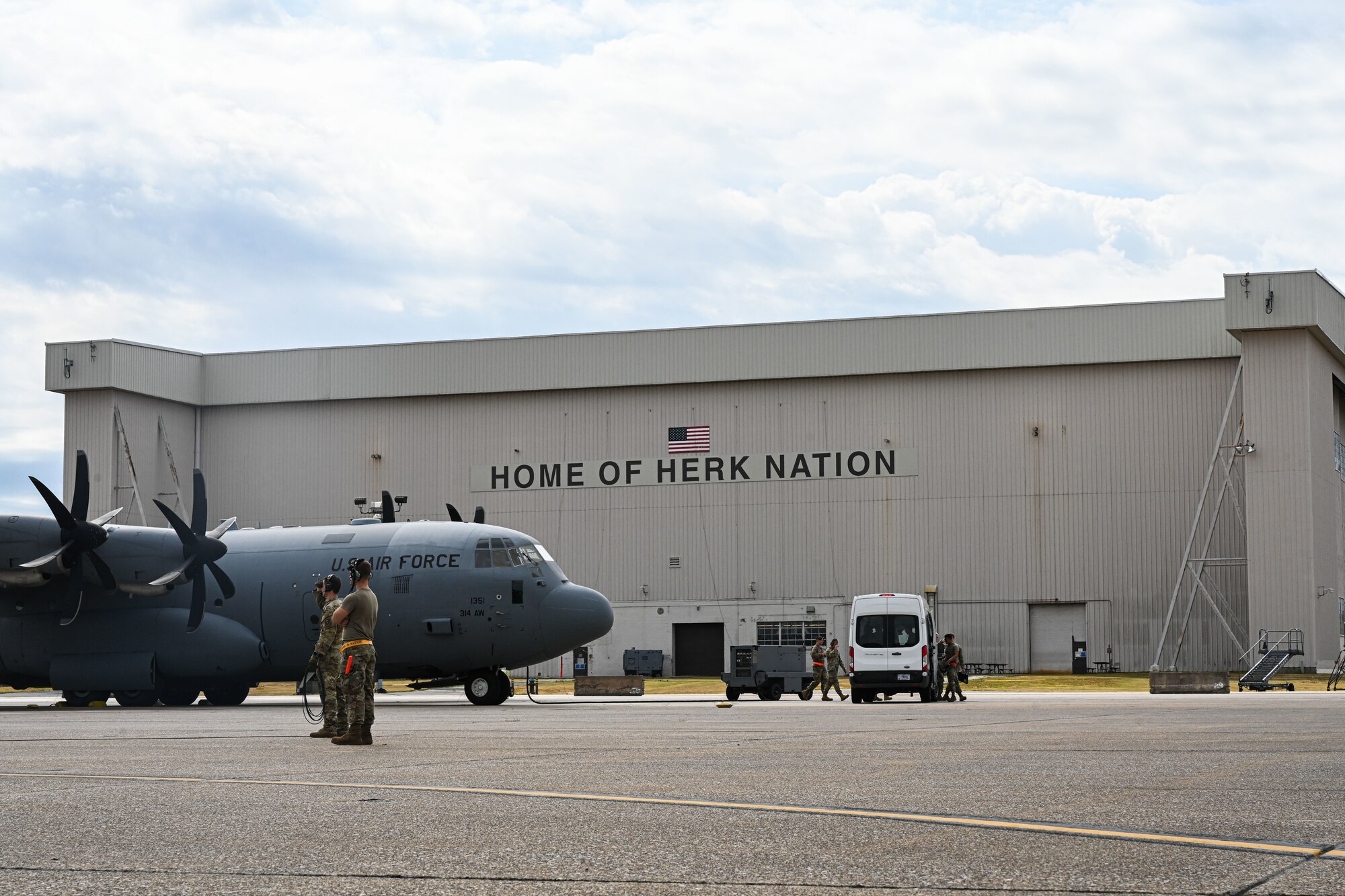 Airmen stand on the flightline.