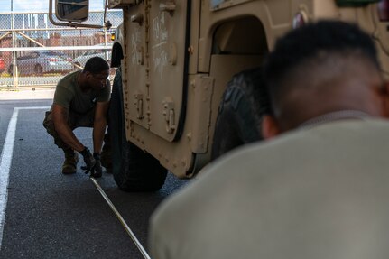 U.S. Soldiers from the 3rd Expeditionary Sustainment Command measure the dimensions of a Humvee.