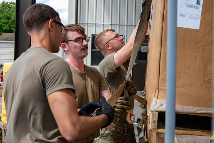 U.S. Air Force Airmen from the 437th Aerial Port Squadron show U.S.Soldiers from the 3rd Expeditionary Sustainment Command how to prepare equipment for flight.