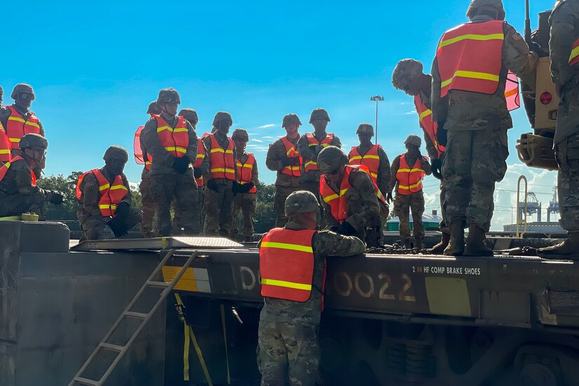 U.S. Soldiers with the 3rd Expeditionary Sustainment Command learn how to tie down equipment on a supply train.