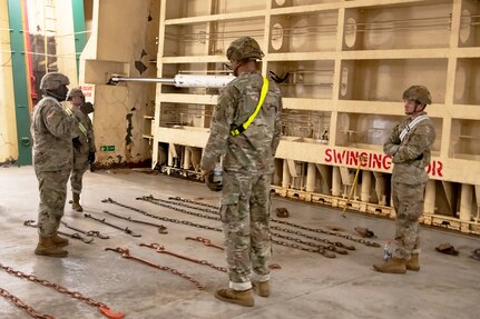 U.S. Soldiers with the 3rd Expeditionary Sustainment Command learn how to secure equipment on a supply ship.