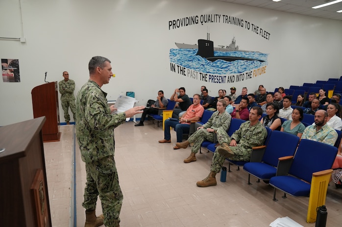LCDR addresses the command during an All Hands event.