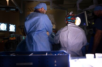 military medical professionals in gowns observe surgery