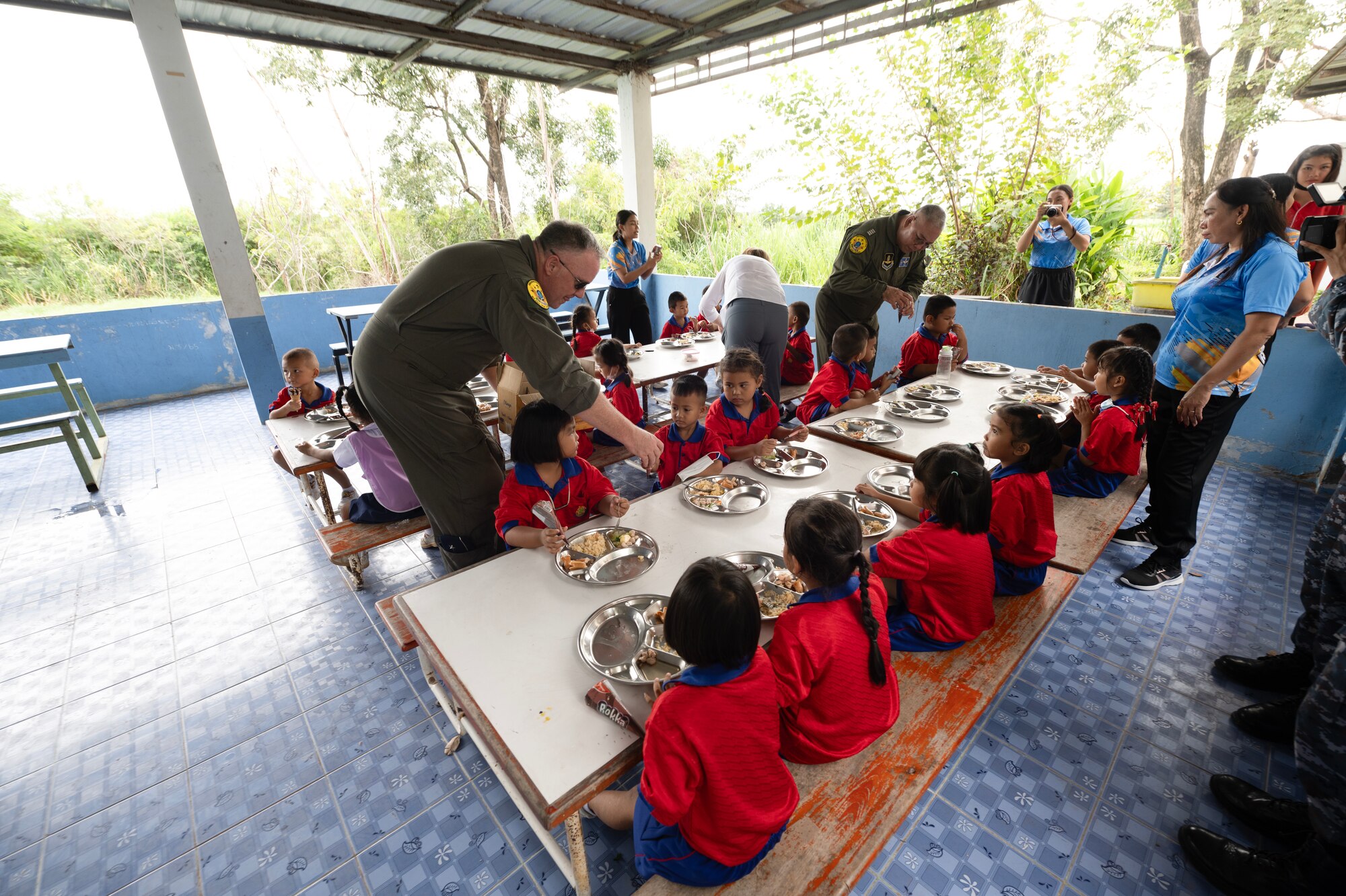 U.S. Air Force Brig. Gen. Gent Welsh, Washington Air National Guard Commander, and Royal Thai Air Force Group Captain Nat Kamintra, exercise director, pass out ice cream to the children of Nong Phluang Yai primary school, Korat, Royal Kingdom of Thailand, September 13, 2023. This community outreach partnership was a core part of the Enduring Partners 2023 exercise between the Kingdom of Thailand, the Washington and Oregon Air National Guard. The school visit gave a chance to connect U.S. military, Royal Thai military and the community of Korat. (U.S. Air Force photo by Tech. Sgt. Michael L. Brown)