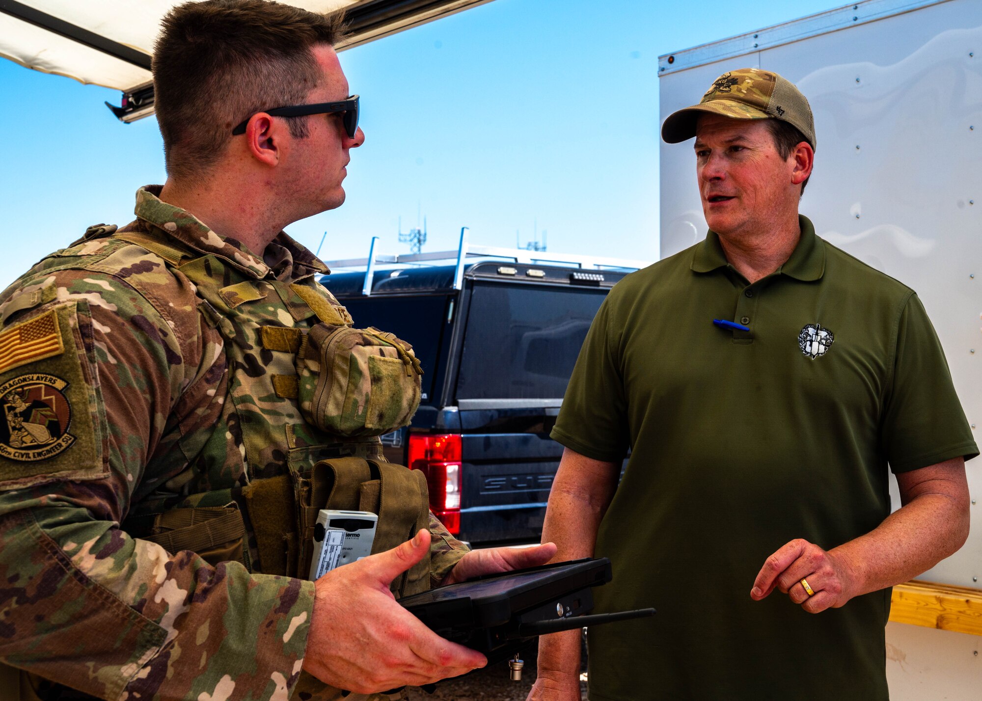 U.S. Air Force Staff Sgt. Zackary Stringer (left), 56th Civil Engineer Squadron explosive ordnance disposal technician, briefs Matt Lightfoot, FBI Phoenix weapon of mass destruction coordinator and bomb technician, during training exercise Road RAPTER or Radiological Assistance Program Training for Emergency Response Sept. 7, 2023, at Luke Air Force Base, Arizona.